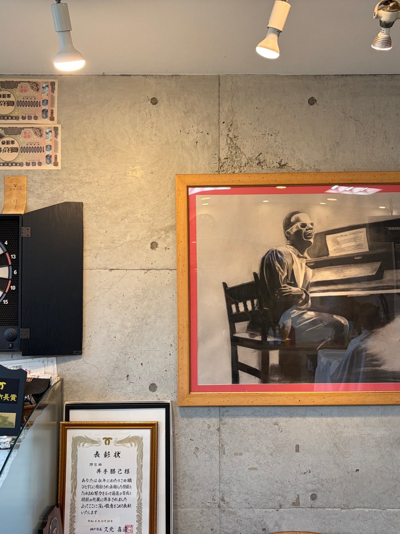 店内の壁に飾られた絵画とダーツボード